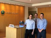 Elan Louis, James Noble, and Stephan Mayer posing with an edition of "Merritt's Neurology"